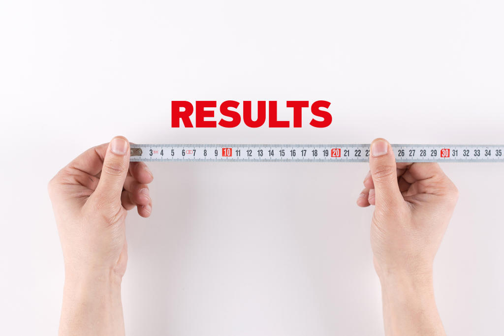 Two hands hold a measuring tape beneath the word RESULTS in bold red letters on...