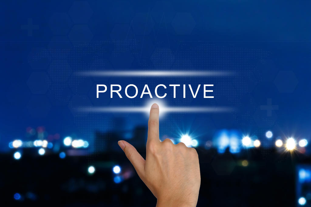 A hand points to the word PROACTIVE glowing on a virtual screen, with a blurred...